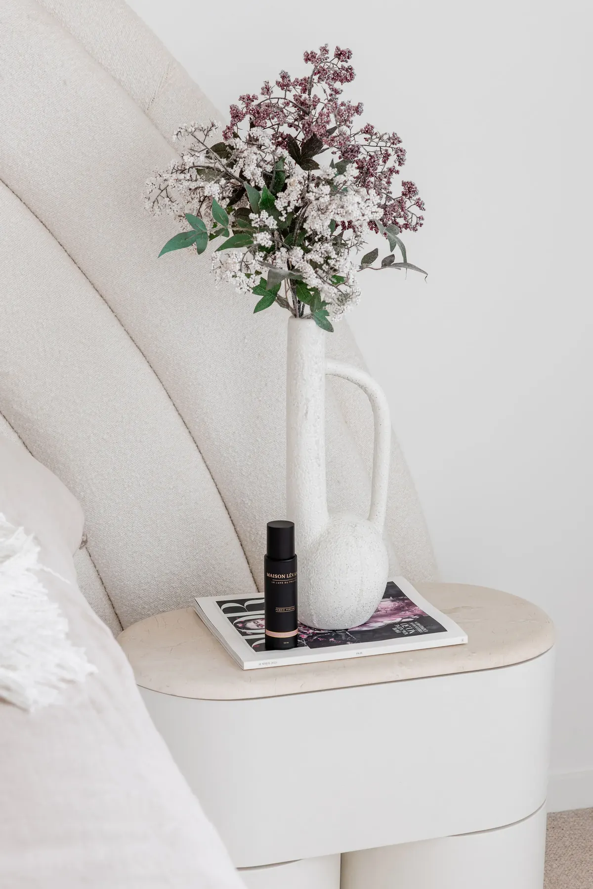 Fabric Perfume on a bedside table beside fresh flowers